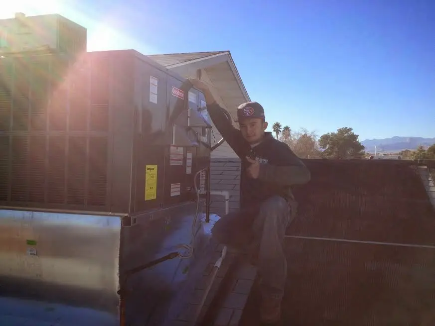 HVAC technician performing AC Tune-Up on a rooftop unit in New Ipswich
